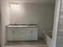Bathroom featuring a double vanity, granite countertop and a soaking tub, designed for comfort and style at 2218 Nw 23Rd Loop, Ocala, FL 34475