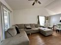 Spacious living room featuring an oversized gray sofa, vaulted ceilings, and wood-look floors at 3617 Westland Dr, Orlando, FL 32818