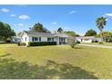 Lovely one-story house featuring blue shutters, a well-kept lawn, and mature trees at 10190 Se 178Th St, Summerfield, FL 34491