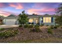 Charming single-story home featuring a three-car garage, covered porch, and landscaped front yard at 10445 Sw 90Th Street Rd, Ocala, FL 34481