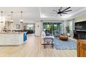 Open-concept living room with wood-look tile flooring, stylish decor, and access to the screened lanai at 10445 Sw 90Th Street Rd, Ocala, FL 34481