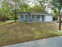 Well-maintained single-story home featuring blue siding, a one-car garage, and a landscaped front yard with mature trees at 10955 Sw 89Th Ave, Ocala, FL 34481