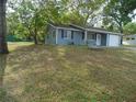 Single-story home with blue siding, a one-car garage, and a well-maintained front lawn at 10955 Sw 89Th Ave, Ocala, FL 34481