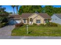 Inviting single-story home featuring an attached garage, manicured lawn, and mature trees at 11645 Sw 75Th Cir, Ocala, FL 34476