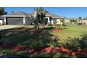 Charming single-story home with lovely landscaping, a green lawn, and an attached garage at 137 Juniper Loop, Ocala, FL 34480