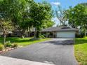 Charming single-story home with an expansive driveway and mature trees in a well-manicured front yard at 1505 Se 27Th Ter, Ocala, FL 34471