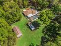 An aerial view showing the pool, additional outbuildings, and a spacious backyard, all surrounded by mature trees at 16 Northern Dancer Dr, Ocala, FL 34482