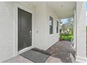 Charming front porch with a dark door and red brick base, accented by greenery and flowers at 3920 Se 7Th Ave, Ocala, FL 34480
