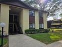 Two story condo building featuring a stucco exterior, dark brown trim, and lush lawn at 501 Fairways Ln # A, Ocala, FL 34472