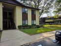 A view of a yellow and brown two-story condo building with stairs and a walkway at 501 Fairways Ln # A, Ocala, FL 34472