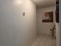Hallway featuring tile flooring, a thermostat, and decorative artwork on the wall at 501 Fairways Ln # A, Ocala, FL 34472