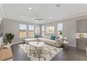 Bright living room featuring a neutral sectional sofa, large windows and a stylish geometric-patterned rug at 5567 Nw 45Th Ln, Ocala, FL 34482