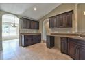 Eat-in kitchen featuring dark cabinets, tile floors, granite countertops, and breakfast bar at 5590 Sw 172Nd Loop, Ocala, FL 34473