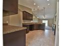 Well-lit kitchen with dark wood cabinets and countertops overlooks the dining and living area at 5590 Sw 172Nd Loop, Ocala, FL 34473