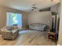 Bright living room featuring updated flooring, a ceiling fan, and natural light from a window at 6082 Sw 104Th St, Ocala, FL 34476
