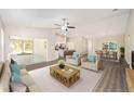Bright living room with light gray walls, wood-look floors, and access to the kitchen and outdoor space at 7798 Sw 134Th Ave, Dunnellon, FL 34432