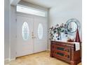 Elegant foyer featuring double doors, decorative transom window, and stylish furniture at 9172 Se 130Th Loop, Summerfield, FL 34491