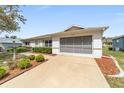 A well-maintained single-story home with a screened garage, complemented by mulch and green landscaping at 9741 Sw 97Th Ln, Ocala, FL 34481