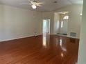 The open living room boasts gleaming hardwood floors, vaulted ceiling, and an arched transom window over the entry door at 11014 Sw 73Rd Cir, Ocala, FL 34476