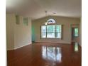 Open living room features vaulted ceilings, a ceiling fan, and large windows for abundant natural light at 11014 Sw 73Rd Cir, Ocala, FL 34476