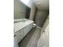 Modern bathroom with a granite countertop vanity and a large tiled walk-in shower at 13269 Sw 112Th St, Dunnellon, FL 34432