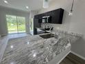 Features a stylish kitchen with granite countertops, dark cabinetry, and stainless steel appliances at 15099 Sw 29Th Terrace Rd, Ocala, FL 34473