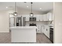 Modern kitchen featuring stainless steel appliances, white cabinets, and a center island at 14390 Sw 30 Pl, Ocala, FL 34481
