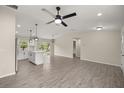 Open-concept living room with a ceiling fan, stylish flooring, and a kitchen island at 14390 Sw 30 Pl, Ocala, FL 34481