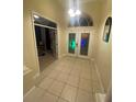 Bright foyer with tile flooring, glass paneled double doors, and an arched transom window at 5323 Sw 111Th Lane Rd, Ocala, FL 34476