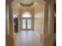 Elegant foyer with tile flooring, arched doorway, decorative glass door and columned entry at 5323 Sw 111Th Lane Rd, Ocala, FL 34476