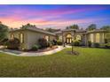 Stunning home exterior at twilight featuring lush landscaping and a manicured lawn at 18498 Sw 69Th Loop, Dunnellon, FL 34432