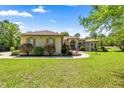 Beautiful single-story home with manicured front lawn and mature landscaping on a sunny day at 18498 Sw 69Th Loop, Dunnellon, FL 34432