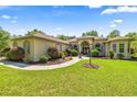 Well-maintained single-story home with arched entryway and lush landscaping at 18498 Sw 69Th Loop, Dunnellon, FL 34432