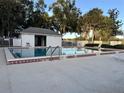Community swimming pool with tiled edge, lounge chairs and adjacent changing room for residents' outdoor enjoyment at 8142 Fairways Cir # S204, Ocala, FL 34472