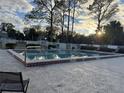 Community pool with decorative tile, mature trees, and ample deck for lounging and catching the sun at 8232 Fairways Cir # D101, Ocala, FL 34472