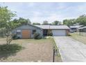 Charming single-story home with a well-manicured lawn and a long driveway leading to an attached garage at 3990 Se 20Th Ct, Ocala, FL 34480
