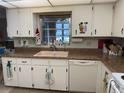 A kitchen featuring white cabinets, and a window above the sink at 8665 Sw 94Th St # C, Ocala, FL 34481
