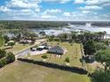 Beautiful aerial view of the property with lush landscaping and a picturesque lake in the background at 11395 Se 108Th Terrace Rd, Belleview, FL 34420