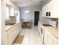 Updated kitchen features white cabinetry, modern appliances, and tile floors at 11495 Sw 138Th Ln, Dunnellon, FL 34432