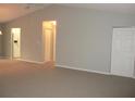 Neutral living room featuring neutral paint, carpeted floors, 2 closets and views of the kitchen at 11495 Sw 138Th Ln, Dunnellon, FL 34432
