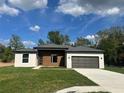 A welcoming single-story home boasts a gray roof, a one-car garage, and fresh green lawn at 11555 Sw 59Th Ter, Ocala, FL 34476