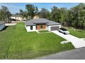 Aerial view of a modern home featuring a well-maintained lawn and a car parked in the long driveway at 11555 Sw 59Th Ter, Ocala, FL 34476