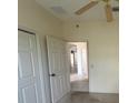 This room offers neutral paint, a ceiling fan, and a view into other rooms of the house at 1703 Sanderling St, The Villages, FL 32162