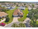Aerial view of a well-maintained home with manicured lawns in a peaceful neighborhood with lush trees at 17645 Se 117Th Cir, Summerfield, FL 34491