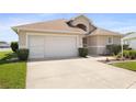 Charming one-story home with a well-maintained lawn, two-car garage, and beautifully manicured shrubs at 17645 Se 117Th Cir, Summerfield, FL 34491
