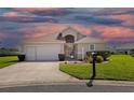 Charming one-story home with a well-maintained lawn, two-car garage, and beautiful evening sky at 17645 Se 117Th Cir, Summerfield, FL 34491