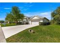 Charming single-story home featuring a well-manicured lawn, mature tree, and a two-car garage with light colored driveway at 2358 Nw 59Th Ter, Ocala, FL 34482