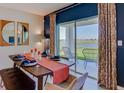 Dining area with an outdoor view, decorative place settings, modern furniture, and stylish curtains and wall decor at 373 Hickory Course Trl, Ocala, FL 34472