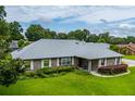 A beautifully landscaped home featuring a well maintained lawn, mature landscaping, and brick facade at 828 Ne 51St Ave, Ocala, FL 34470
