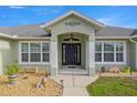 The home's front entrance features decorative columns, a dark wood door, and well-manicured landscaping at 9957 Sw 55Th Avenue Rd, Ocala, FL 34476